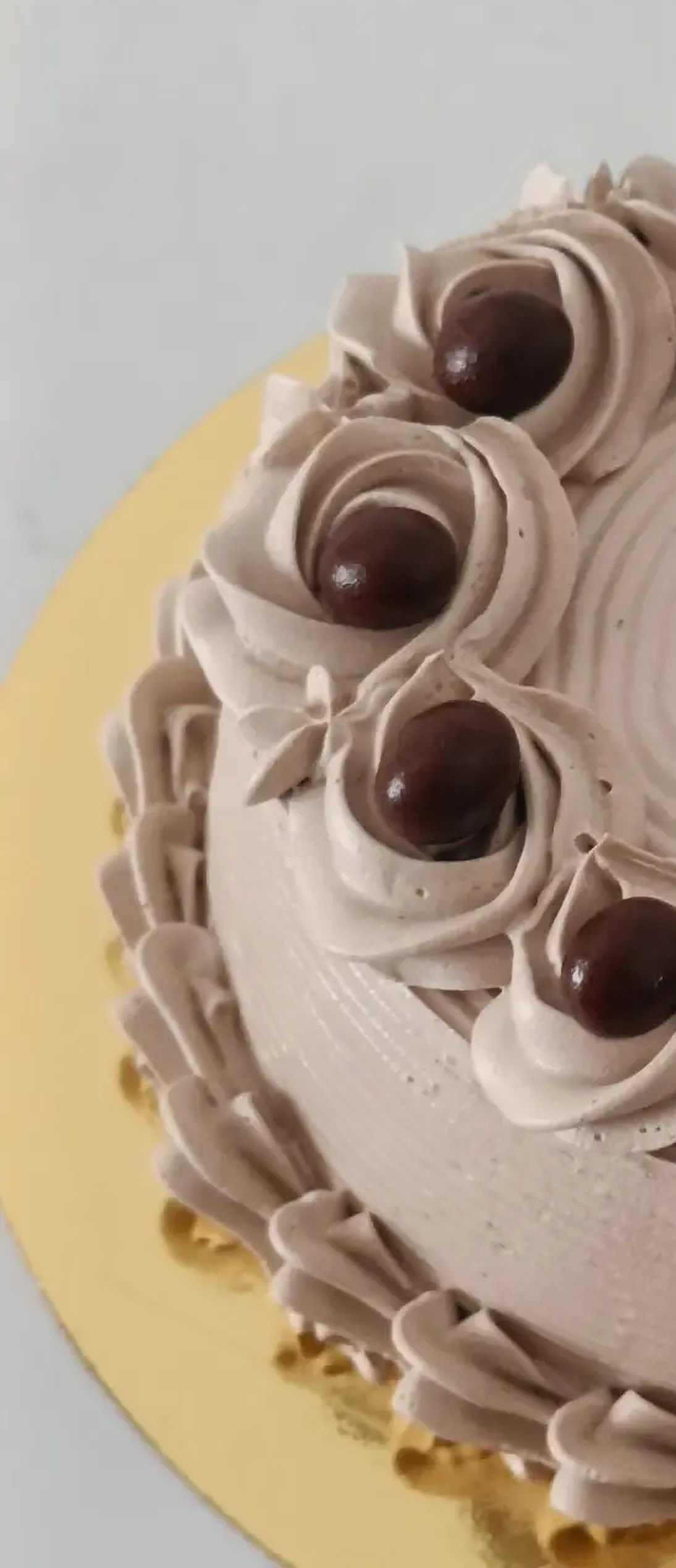 Chocolate cream cake with piped rosettes and chocolate pearls